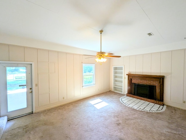 602 Cobb Rd, Dothan, AL 36301 - unfurnished living room featuring carpet floors, a decorative wall, a ceiling fan, and a brick fireplace