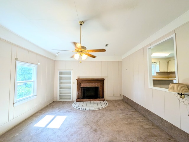 602 Cobb Rd, Dothan, AL 36301 - unfurnished living room featuring carpet floors, a brick fireplace, ceiling fan, a decorative wall, and ornamental molding