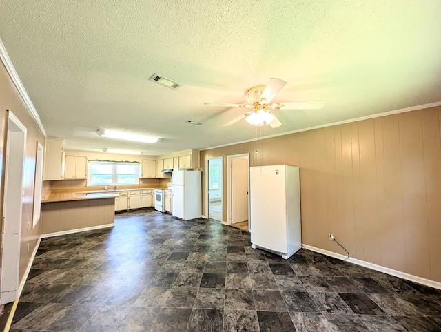 602 Cobb Rd, Dothan, AL 36301 - kitchen with freestanding refrigerator, a ceiling fan, crown molding, a peninsula, and wooden walls