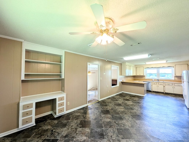 602 Cobb Rd, Dothan, AL 36301 - kitchen featuring a textured ceiling, a peninsula, ceiling fan, freestanding refrigerator, and crown molding