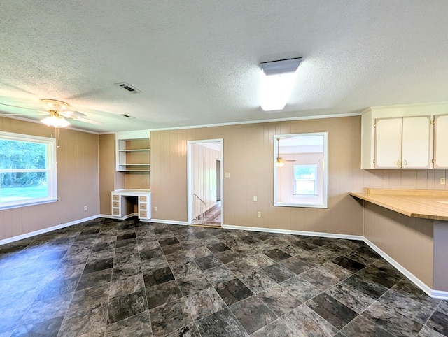 602 Cobb Rd, Dothan, AL 36301 - unfurnished living room with ceiling fan, a textured ceiling, ornamental molding, and wood walls