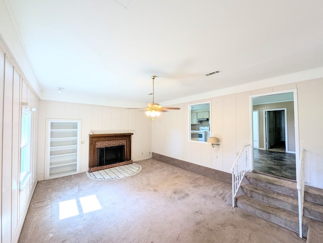 602 Cobb Rd, Dothan, AL 36301 - unfurnished living room featuring carpet flooring, a fireplace, ceiling fan, stairs, and ornamental molding