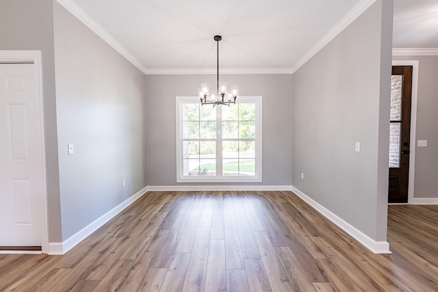 unfurnished dining area featuring wood-type flooring, an inviting chandelier, and ornamental molding