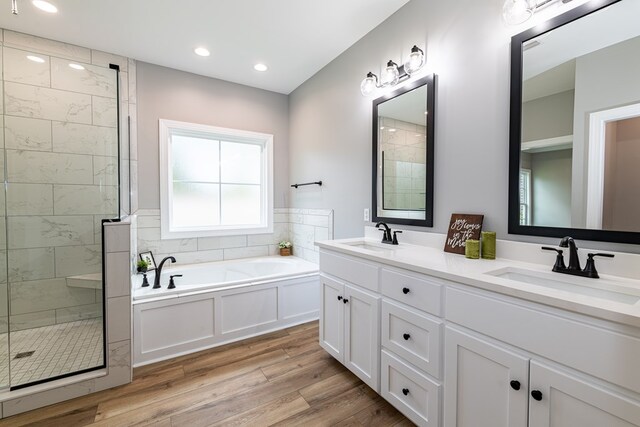 bathroom featuring hardwood / wood-style floors, vanity, and independent shower and bath