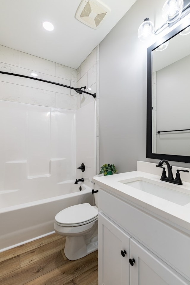 full bathroom with toilet, vanity, tiled shower / bath combo, and hardwood / wood-style flooring