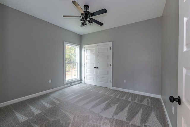 unfurnished bedroom with carpet flooring, a closet, and ceiling fan