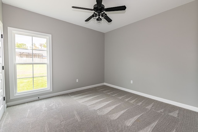 carpeted empty room with a wealth of natural light and ceiling fan