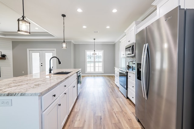 kitchen featuring sink, stainless steel appliances, pendant lighting, a kitchen island with sink, and white cabinets