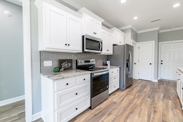 kitchen featuring light wood-type flooring, backsplash, stainless steel appliances, crown molding, and white cabinetry