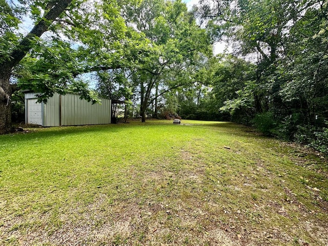 959 S Saint Andrews St, Dothan, AL 36301 - view of grassy yard featuring an outdoor structure, a garage, and an outbuilding