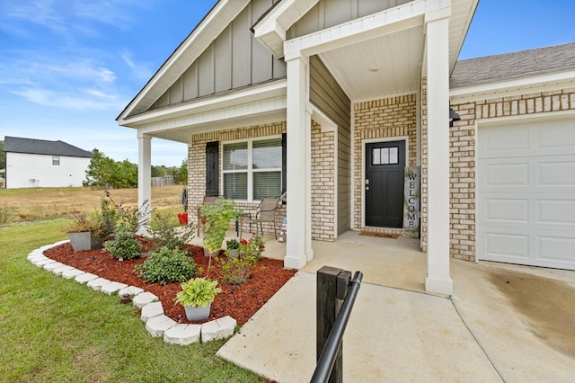 property entrance featuring covered porch and a garage