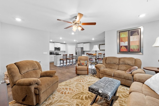 living room with ceiling fan and wood-type flooring