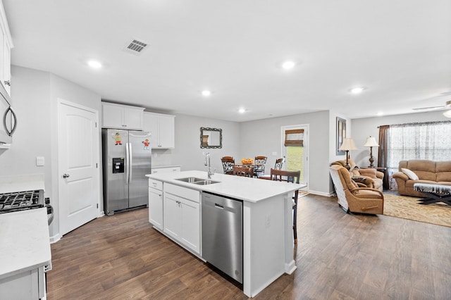 kitchen featuring white cabinets, appliances with stainless steel finishes, a kitchen island with sink, and sink