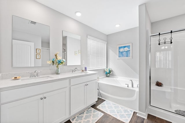 bathroom with hardwood / wood-style floors, vanity, and independent shower and bath