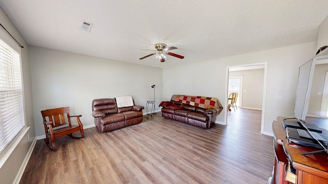 284 Alec Cir, Ozark, AL 36360 - living room featuring wood finished floors, healthy amount of natural light, ceiling fan, baseboards, and a textured ceiling