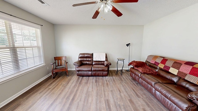 284 Alec Cir, Ozark, AL 36360 - living room with wood finished floors, ceiling fan, a textured ceiling, and baseboards
