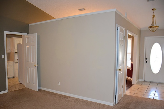 entryway featuring baseboards, light carpet, light tile patterned flooring, and ornamental molding