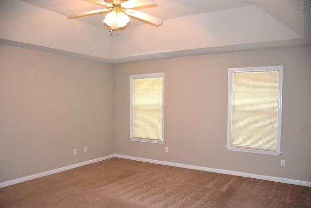 carpeted empty room featuring baseboards and ceiling fan