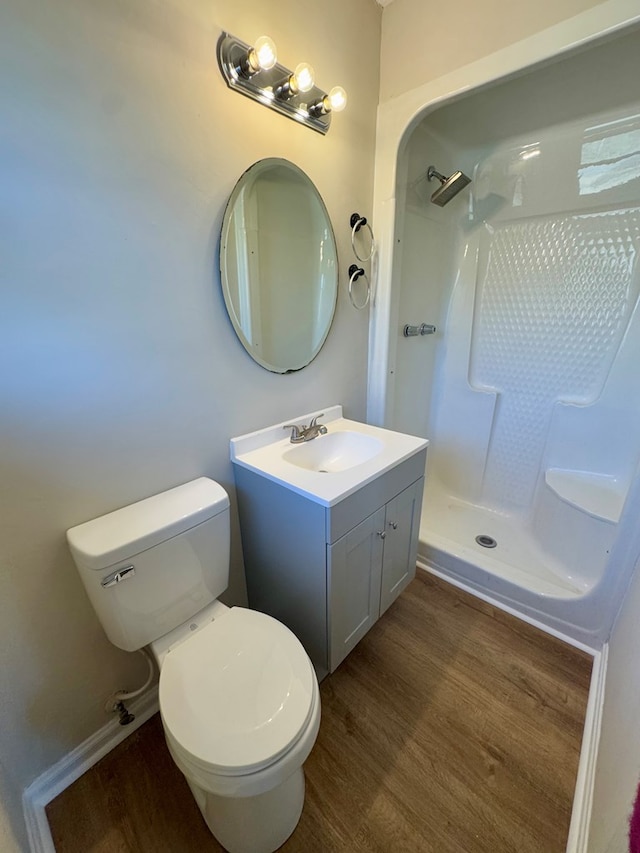 bathroom with vanity, hardwood / wood-style floors, toilet, and walk in shower