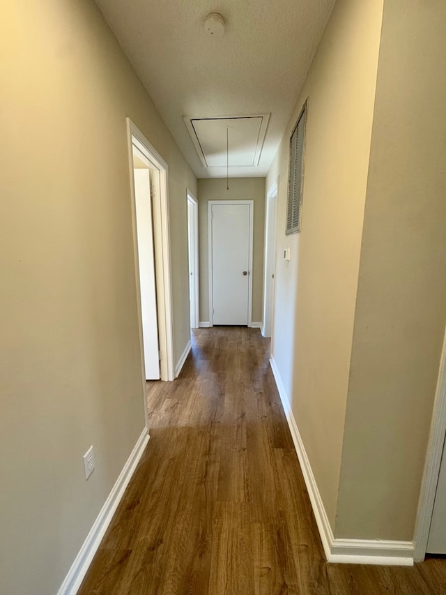 hallway featuring hardwood / wood-style floors and a textured ceiling