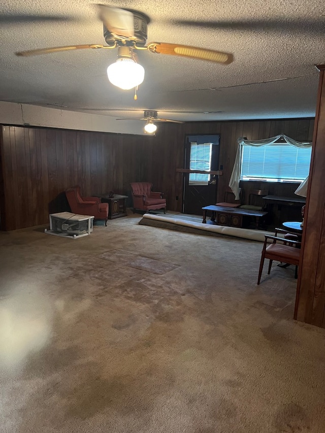 interior space with carpet flooring, a textured ceiling, and ceiling fan