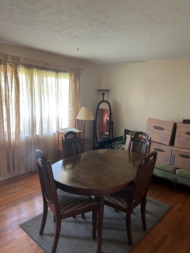 dining room featuring light hardwood / wood-style flooring and a textured ceiling