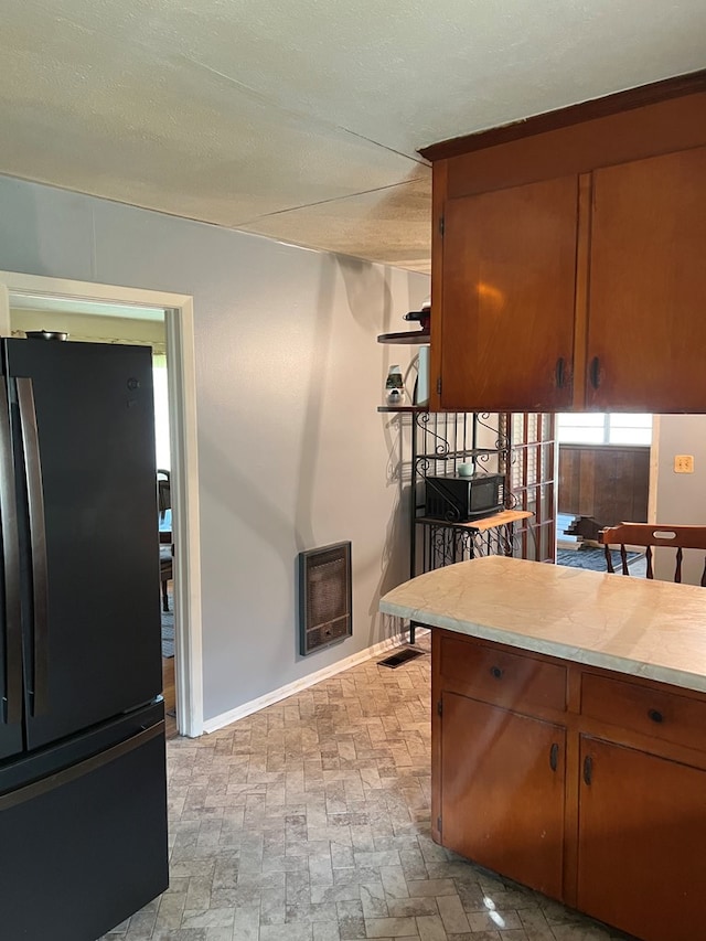 kitchen featuring heating unit and black appliances