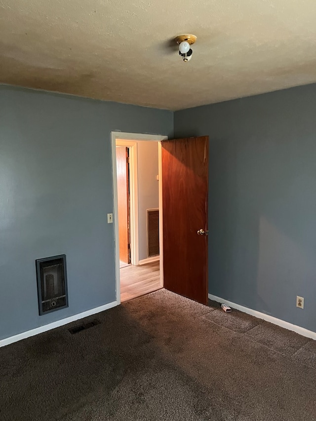 spare room featuring a textured ceiling and carpet