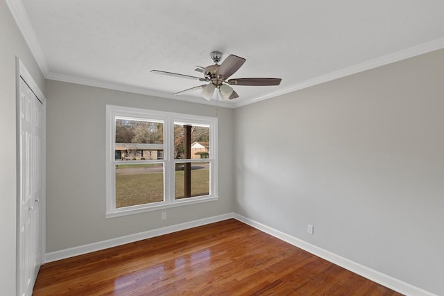 unfurnished bedroom featuring crown molding, hardwood / wood-style flooring, a closet, and ceiling fan