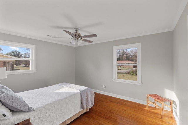 bedroom featuring hardwood / wood-style flooring, ceiling fan, and ornamental molding