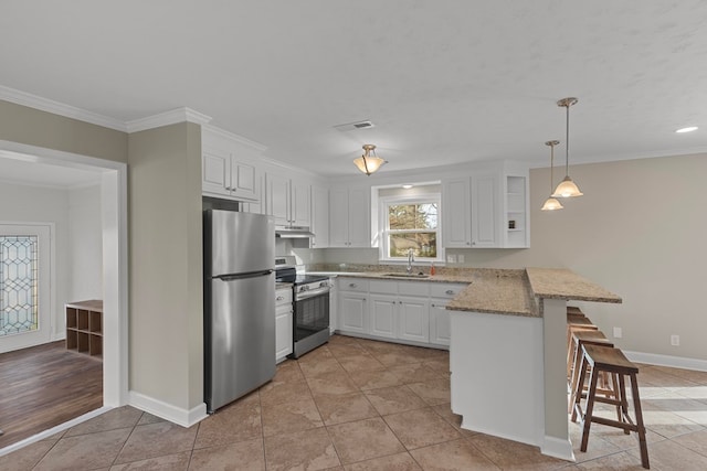 kitchen featuring sink, a kitchen breakfast bar, kitchen peninsula, stainless steel appliances, and white cabinets