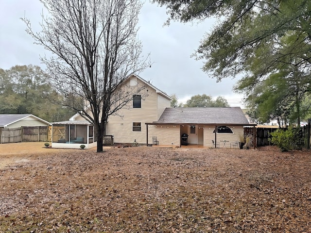 back of property with a sunroom