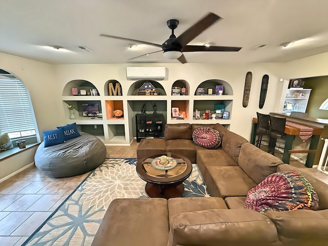 living room with an AC wall unit, built in shelves, and ceiling fan