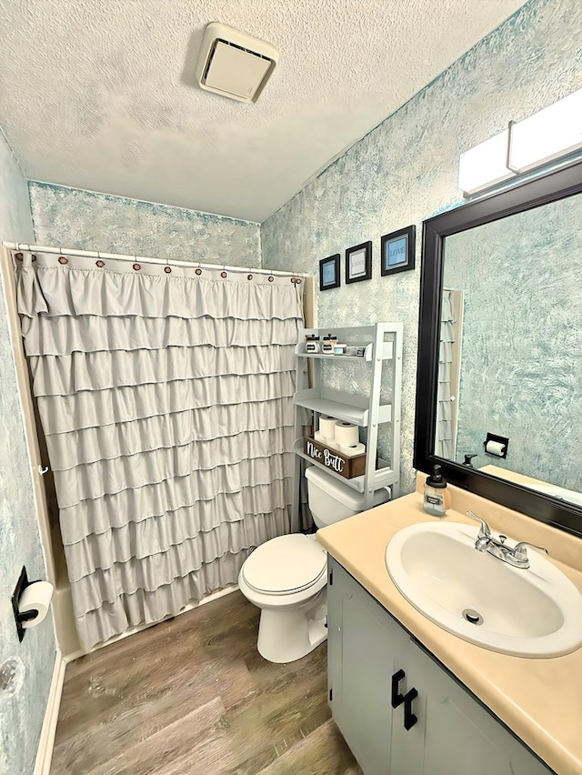 bathroom featuring hardwood / wood-style floors, toilet, vanity, and a textured ceiling