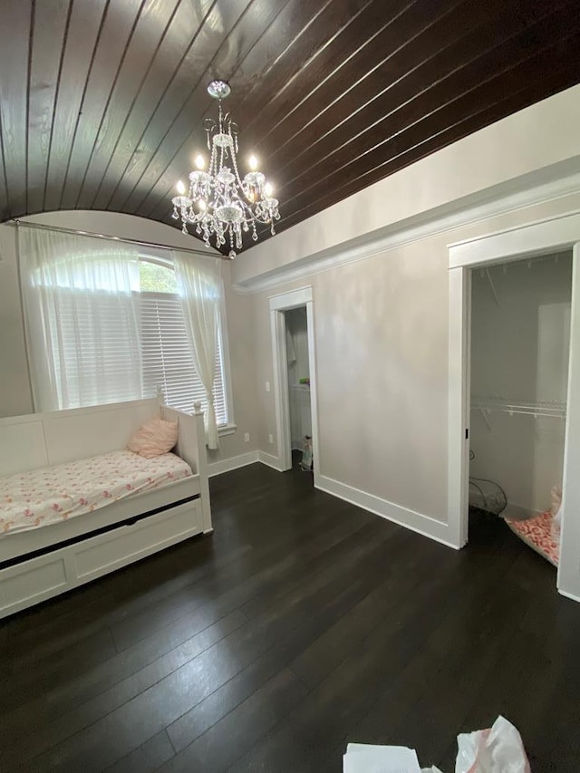 unfurnished bedroom with dark hardwood / wood-style floors, an inviting chandelier, wood ceiling, and a closet