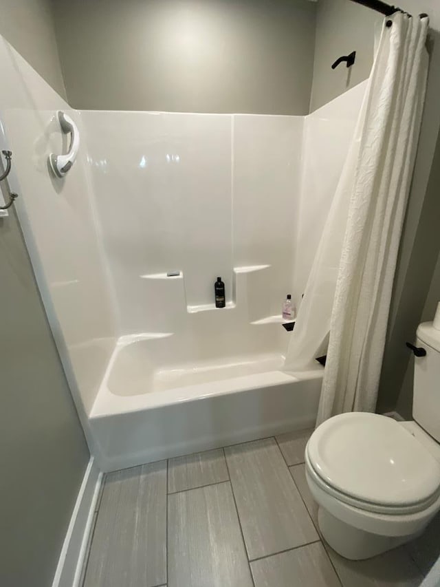 bathroom featuring shower / bath combo and toilet