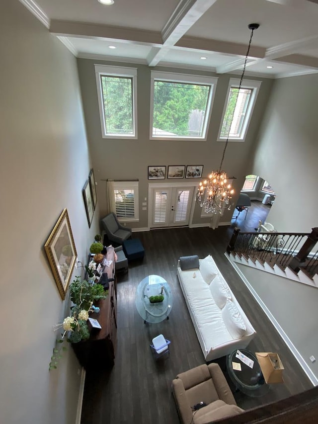 living room featuring ornamental molding, coffered ceiling, beam ceiling, a chandelier, and dark hardwood / wood-style floors