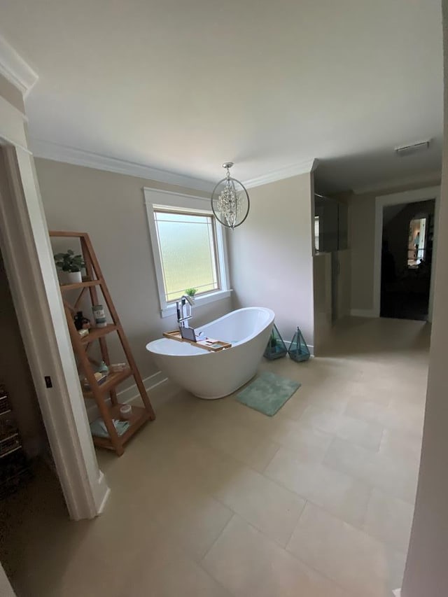 bathroom featuring a bathtub, ornamental molding, and an inviting chandelier