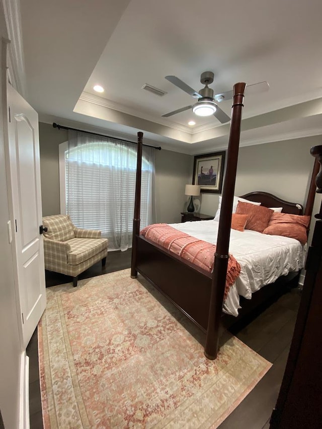 bedroom with ceiling fan, ornamental molding, and a tray ceiling