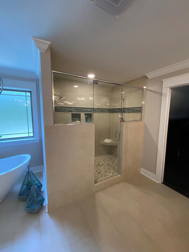 bathroom with ornamental molding and independent shower and bath