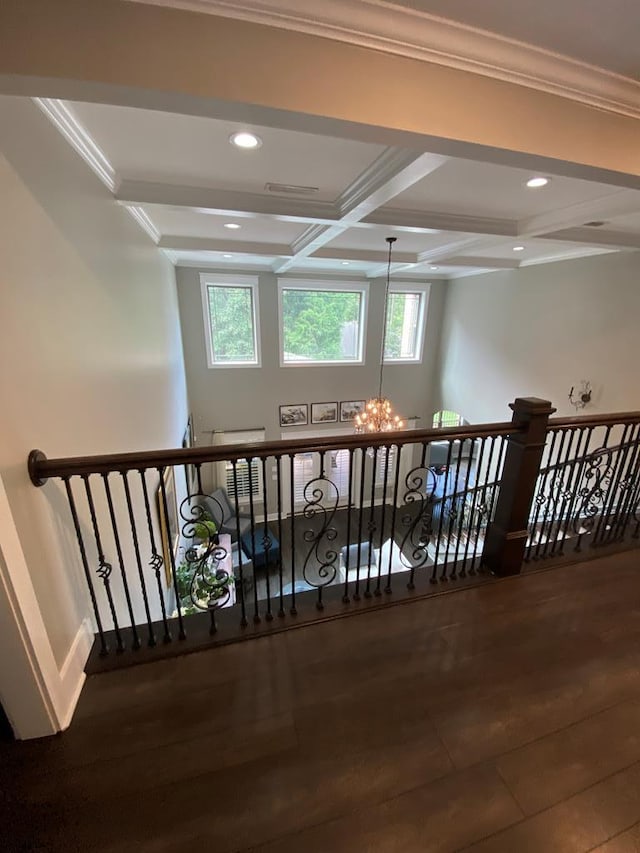 hall with wood-type flooring, a wealth of natural light, a notable chandelier, and coffered ceiling