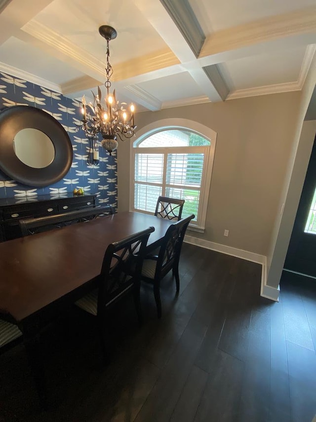 dining area with dark wood-type flooring, coffered ceiling, an inviting chandelier, ornamental molding, and beamed ceiling