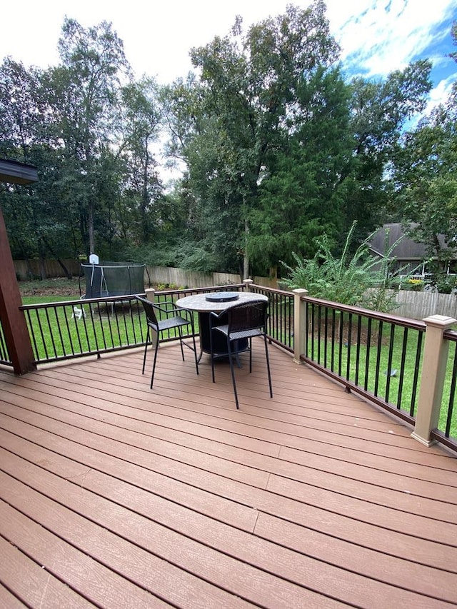 wooden deck featuring a yard and a trampoline