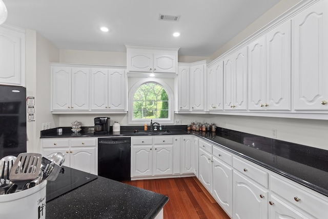 kitchen with white cabinets, a sink, recessed lighting, dark wood-type flooring, and black appliances