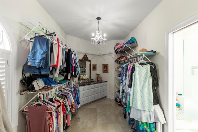 walk in closet featuring light tile patterned flooring and a notable chandelier