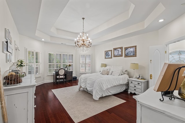 bedroom featuring an inviting chandelier, recessed lighting, a raised ceiling, and dark wood finished floors