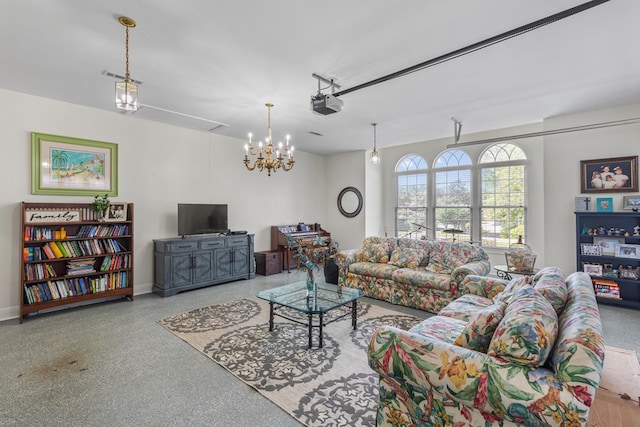 living room featuring speckled floor, baseboards, and attic access