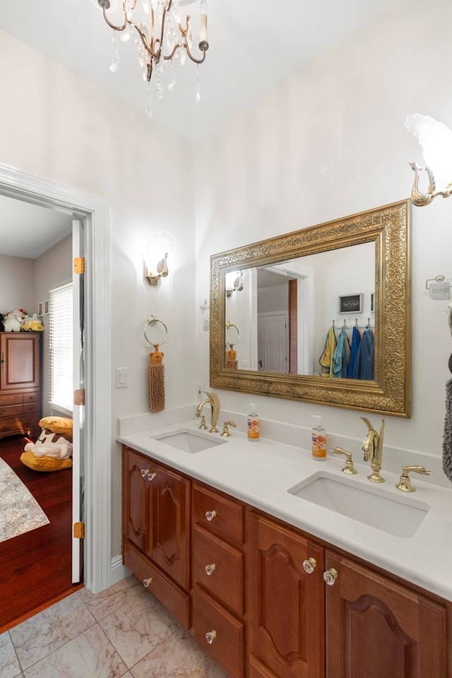 full bathroom featuring an inviting chandelier, a sink, and double vanity