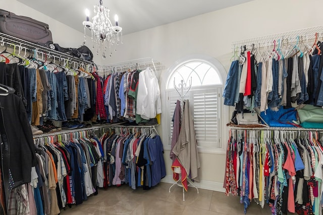 spacious closet with tile patterned floors and an inviting chandelier