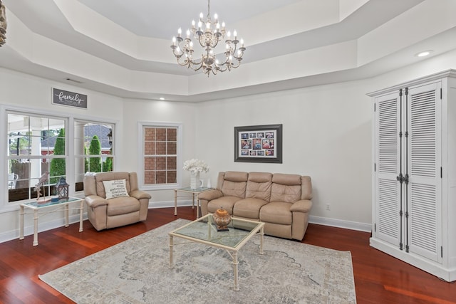 living room with dark wood-type flooring and a raised ceiling